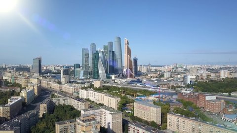 Aerial view of drone Moscow city skyscrapers through sun rays. Business center of Moscow-city. International towers and houses of capital of Russia with solar flare. Traffic from above birds eye view