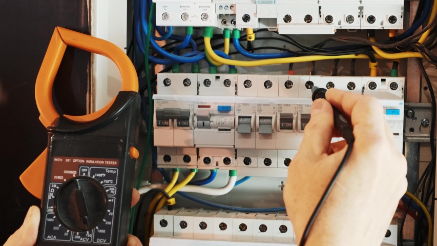 Electricians hands testing current  electric in control panel. Electrician engineer work  tester measuring  voltage and current of power electric line in electical cabinet control. Royalty-Free Stock Footage #1054147112