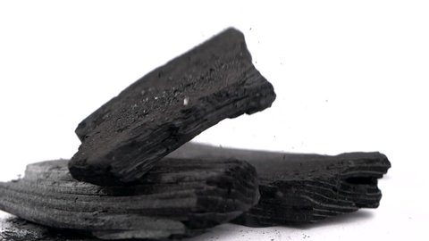 Charcoal falling in slow motion, traditional charcoal or hard wood charcoal on white background.