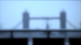 Intentionally blurred defocused background of anonymous pedestrians in silhouette walking in the city of London. Tower Bridge on the background. Blue pastel cold tone. 