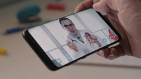 Patient holding a smartphone mobile device to video chat with a Cardiologist medical doctor for an online consultation.