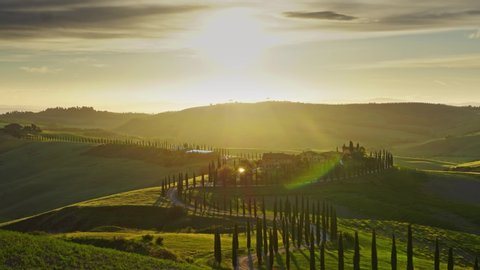 Tuscany landscape with road and cypresses of farmland hill country at sunset. Italy, Europe, zoom out timelapse 4k