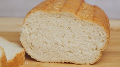 man checks freshness of bread by clicking on loaf with hand close-up.