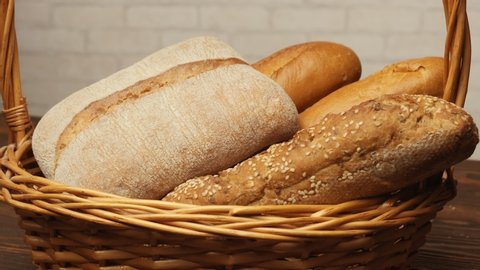 basket with bread rotating on table on light background.