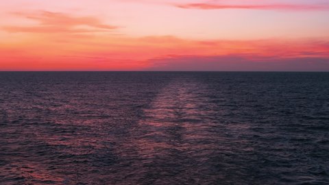 Cruise ship wake with beautiful sunset on water. Destination vacation travel tropical ocean sea. Beautiful blue Caribbean Ocean water wake behind large cruise ship.