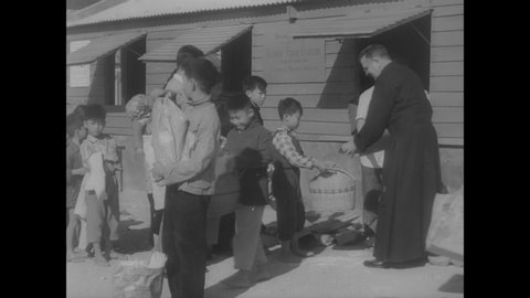 CIRCA 1959 - Refugees from mainland China receive charitable food donations in Hong Kong.