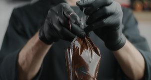 Confectioner ties full pastry bag with an elastic rubber band, melted chocolate filling, cake decoration, slow motion food video, cooking the sweet desserts and candies, 4k 120fps Prores HQ 10 bit