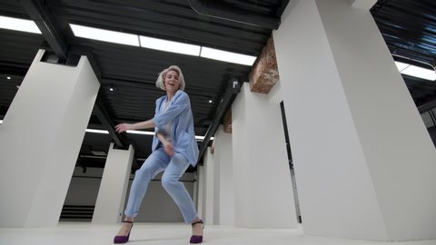 One Confident 30s Businesswomen Celebrate Win No Mask. Carefree Portrait Woman Urban Style Joy Move Indoor Loft Room. Joyful Face with Silly Moves Loop. Concept Quarantine Funny Dancing Wide Shot 4k