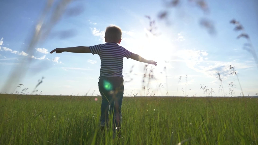 Happy kid in park in field. Kid run his arms to side. Games in park in airplane pilot. Chidhood dream. Kid airplane pilot. Happy kid run in park. Child in field. Child dream at sunset | Shutterstock HD Video #1054168013