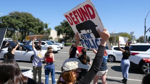 VENTURA, CALIFORNIA - CIRCA 2020 - extreme slo mo signs say defund the police during a Black Lives Matter BLM march in Ventura, California.