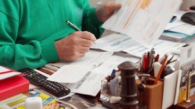 Bank manager sitting in his office and working with piles of documents and files. Senior man reading filled sheets of paper and writing down some notes with green pen. Financial working in office - Powered by Shutterstock - Get 15% off with code: PIKWIZARD15