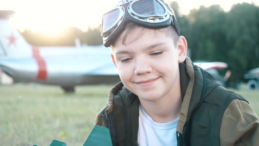 Face Portrait of Smiling Child Boy Wearing Profession Costume, Looking at Camera, Dreaming of Flying, Airplane Adventures Closeup Outdoors. Imagination, Career Fantasy of Little Ambitious Future Pilot Royalty-Free Stock Footage #1054172543