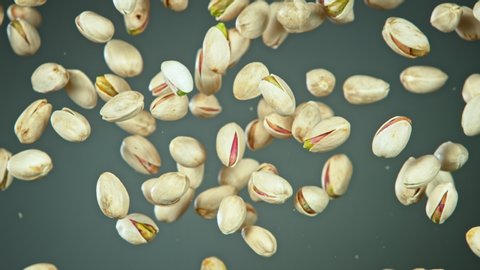 Super Slow Motion Shot of Flying Pistachios After Being Exploded on Grey Gradient Background at 1000fps.