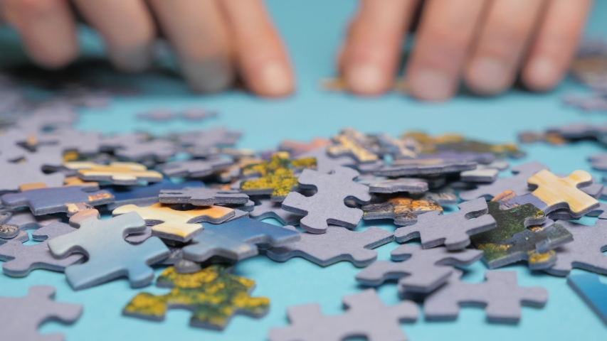 Hands assembling jigsaw puzzle. Teamwork. Way to success. Happy family is engaged in self-development. Symbolizing a painstaking work with high level of accuracy. Problem solution concept. Spend time Royalty-Free Stock Footage #1054178684