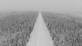 Drone aerial footage of a snowing, remote and wild, wilderness road in northern Canada in the winter time. Dempster Highway in Yukon Territory, Northwest Territories. 
