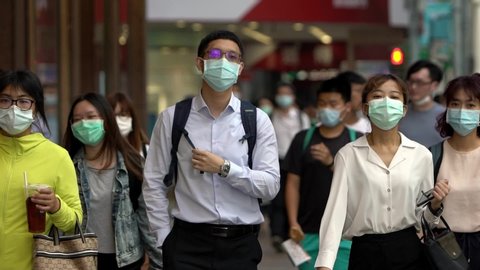 Taipei, Taiwan-04 June, 2020: Slow motion of people wearing face masks during the coronavirus outbreak. Asian pedestrian walking on scramble crossing street, using surgical mask against covid19-Dan