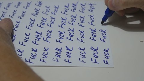 a man writes a protest with a blue marker on a white sheet in the form of one word fuck. Man is tired of everything. Everyone got it. 4K