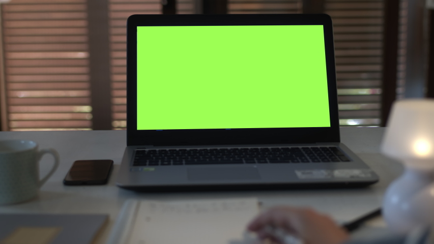 POV personal perspective of student watching a video call online lesson on a laptop with green screen at home. Take notes during a video conference. Chroma key.  Royalty-Free Stock Footage #1054193861