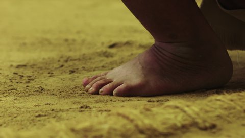 Close up of feet and toes of a Sumo wrestler in Japan. Standing in a traditional yellow sand circle