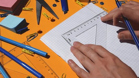 student hand draw triangle on a paper notepad, homework mathematics, back to school, school supplies, elementary school