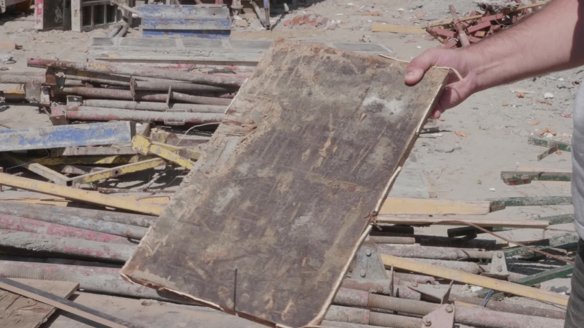 A man twists a board in his hand at a construction site