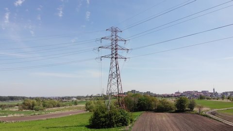 Power pylons and high voltage lines in an agricultural landscape. High-voltage masts. Electricity transmission power lines.4K, UHD, Cinematic, Aerial footage						