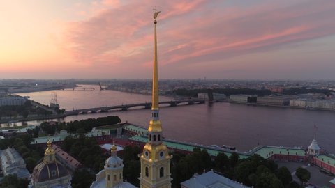 Aerial backwards cinematic dawn St. Petersburg Peter and Paul Fortress romantic cityscape Golden spire weather vane angel. Historical downtown. Neva river, Palace drawbridge. Travel sight. Pink clouds