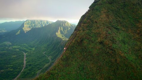 Man climbing stairway to heaven with epic landscape in background, aerial, Hawaii