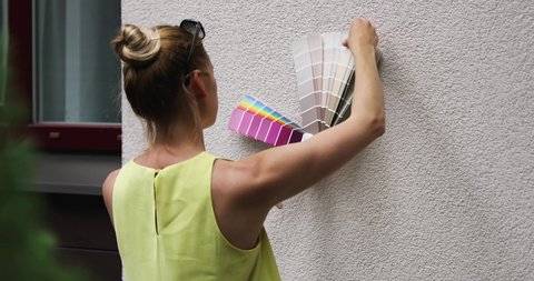 woman choosing paint color for house exterior stucco facade