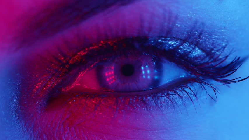 Extreme close up of human eye iris under neon light 4K. Female with beautiful makeup, glitter shadows and false lashes. Womens green eye contracting. Nightlife, night club concept. | Shutterstock HD Video #1054203365