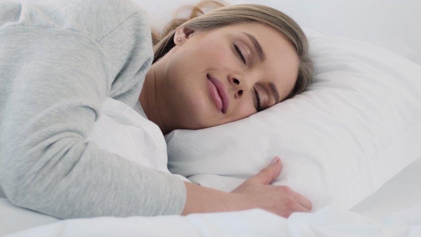 A lovely young woman is sleeping in the white bed at home | Shutterstock HD Video #1054205015