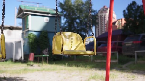 Empty swing on children playground. Playground without anyone. The town empty, loneliness, childhood