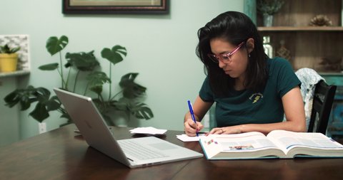 Young Hispanic Student attends online class at home