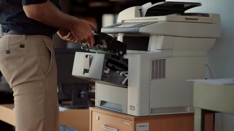 IT Support Copier Maintenance In Office Removing And Changing Toner Tube. Man From Helpdesk Replace Cartridge In Printer. Hand Swapping Cartridge On Multifunctional Printer. Employee Working In Office