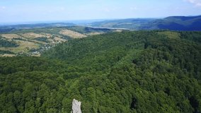 Beautiful drone panoramic view of green forest on the mountains. Moving forward to  mountain valley with sunshine in summer day. 4k nature video.
