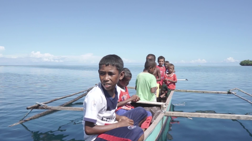 Raja Ampat Islands, West Papua, Indonesia - CIRCA 2020: Papuan People Papuans Melanesians Happy Cheerful Children on The Boat