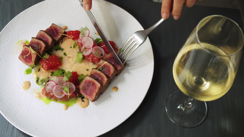 Elegant woman eating tuna tataki steak with colorful salad in high kitchen restaurant, haute cuisine, fine dinning by famous chef, professional gourmet kitchen | Shutterstock HD Video #1054225073