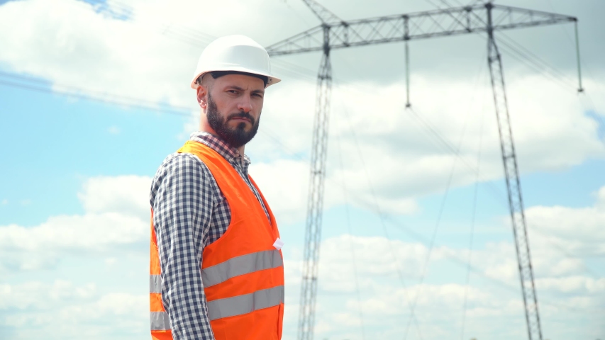 Engineer working near transmission lines. Electricity pylons