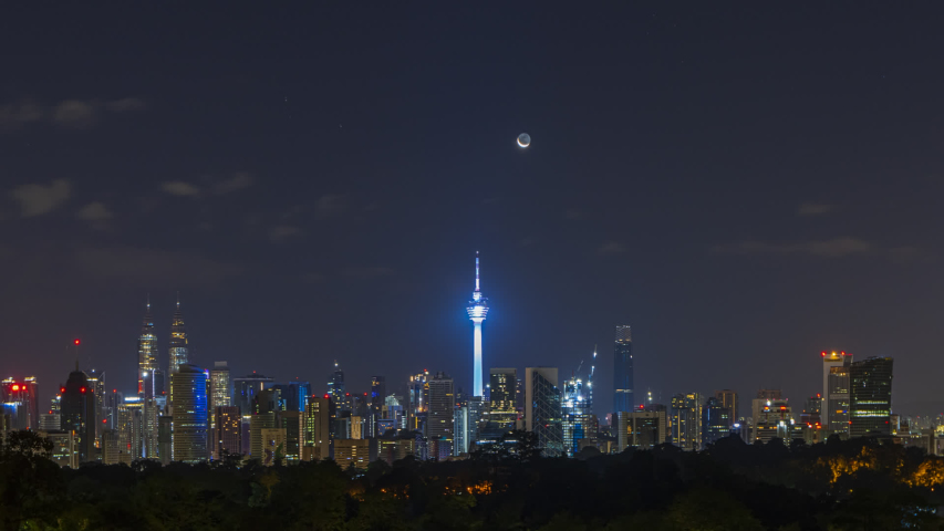 Kuala Lumpur Time lapse: Moonrise over a city view during early morning overlooking Kuala Lumpur skyline from afar with crescent moon setting. Malaysia. Pan left motion. Prores Full HD