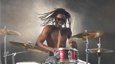 Portrait of african man performing music with use of drum set, handsome black naked man