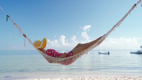 Girl relax in a hammock on tropical island beach