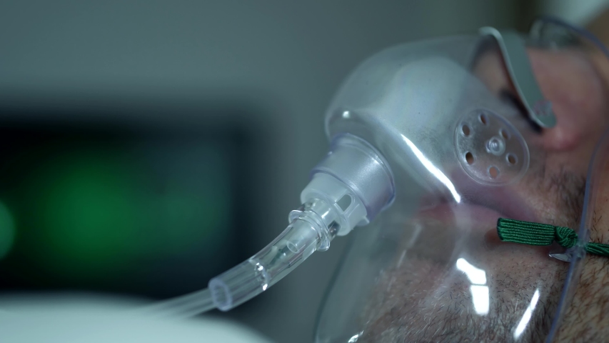 Male Patient Breathing Oxygen Support In Hospital, Next To Heart Rate Machine. Royalty-Free Stock Footage #1054258874