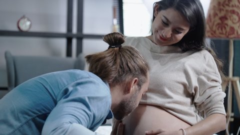 Caucasian family is happy to give birth. Pregnant mother is in good health. Husband and wife watch an X-ray film of a child who is about to be born in the house. 4k slow motion