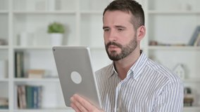 Portrait of Young Man doing Video Chat on Tablet