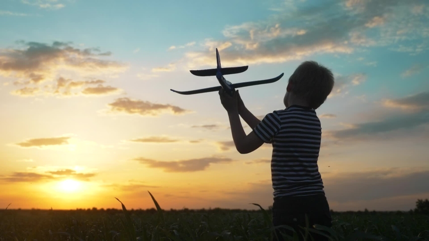 Happy boy child run with an airplane. kid silhouette play plane. happy family dream freedom airplane concept. lifestyle son kid run on wheat field at sunset holds in his hands dream toy aircraft | Shutterstock HD Video #1054277378