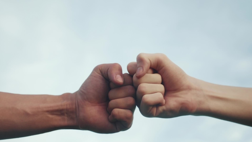 Teamwork concept. fist to fist commit solidarity a respect and brotherhood gesture. lifestyle business team hands fists close-up. people of different skin colors partnership friendship teamwork | Shutterstock HD Video #1054277393