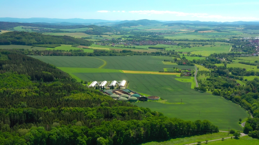 Biogas plant and farm in green fields. Renewable energy from biomass. Aerial view to modern agriculture in Czech Republic and European Union.  | Shutterstock HD Video #1054279124