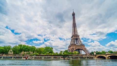 A timelapse of the Eiffel Tower along the river Seine with flyboats passing by with motion blur.Sunny but cloudy summer day paris city famous riverside bay tower view bridge timelapse panorama 