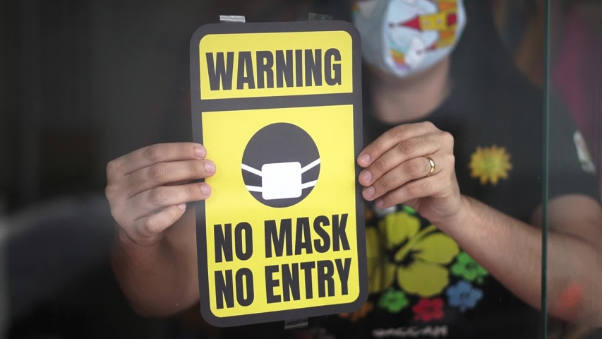 Pandemic concept. Coronavirus warning board saying no mask no entry at the entrance of the store. Avoid infection with face mask. Royalty-Free Stock Footage #1054284545