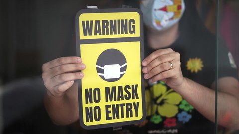 Pandemic concept. Coronavirus warning board saying no mask no entry at the entrance of the store. Avoid infection with face mask.
